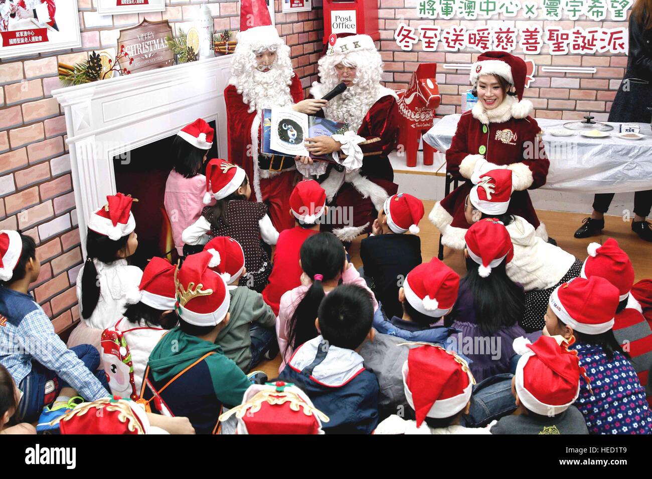 Hong Kong, China. 21 dic, 2016. 'Santa clauses" contar una historia en un evento para celebrar la próxima Navidad en una comunidad en Hong Kong, sur de China, el 21 de diciembre, 2016. © Wang Xi/Xinhua/Alamy Live News Foto de stock
