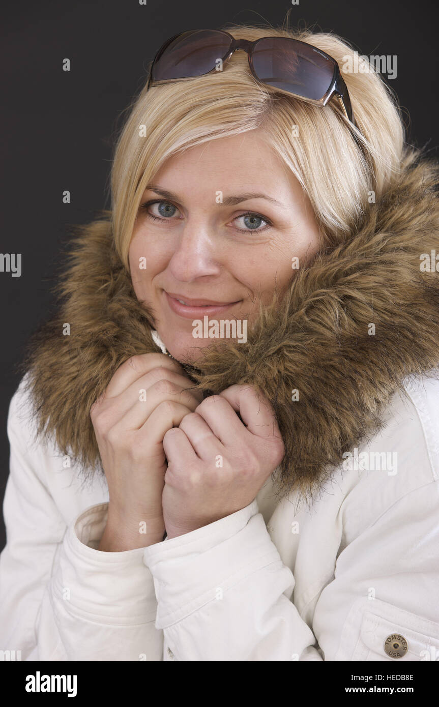 Mujer rubia vistiendo un abrigo de pieles blancas recortadas Foto de stock