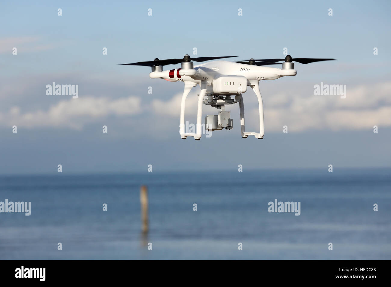 Control remoto blanco Drone Dji Phantom 3 equipado con cámara de vídeo de  alta resolución flotando en el aire con la tierra y el cielo azul  Fotografía de stock - Alamy