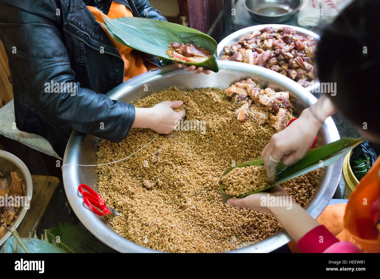 Haciendo Zongzi arroz pegajoso, enrollado en hojas de palmera, Tangqi Antigua Ciudad, Hangzhou, Provincia de Zhejiang, China Foto de stock