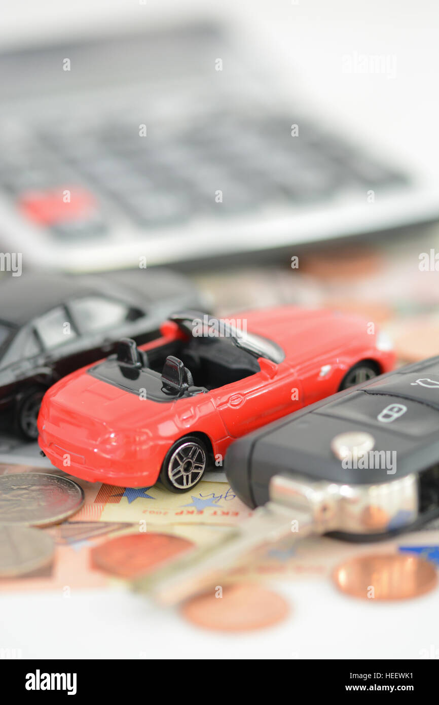 Comprar o alquilar un coche concept car con juguetes, llave de coche, monedas y billetes Foto de stock