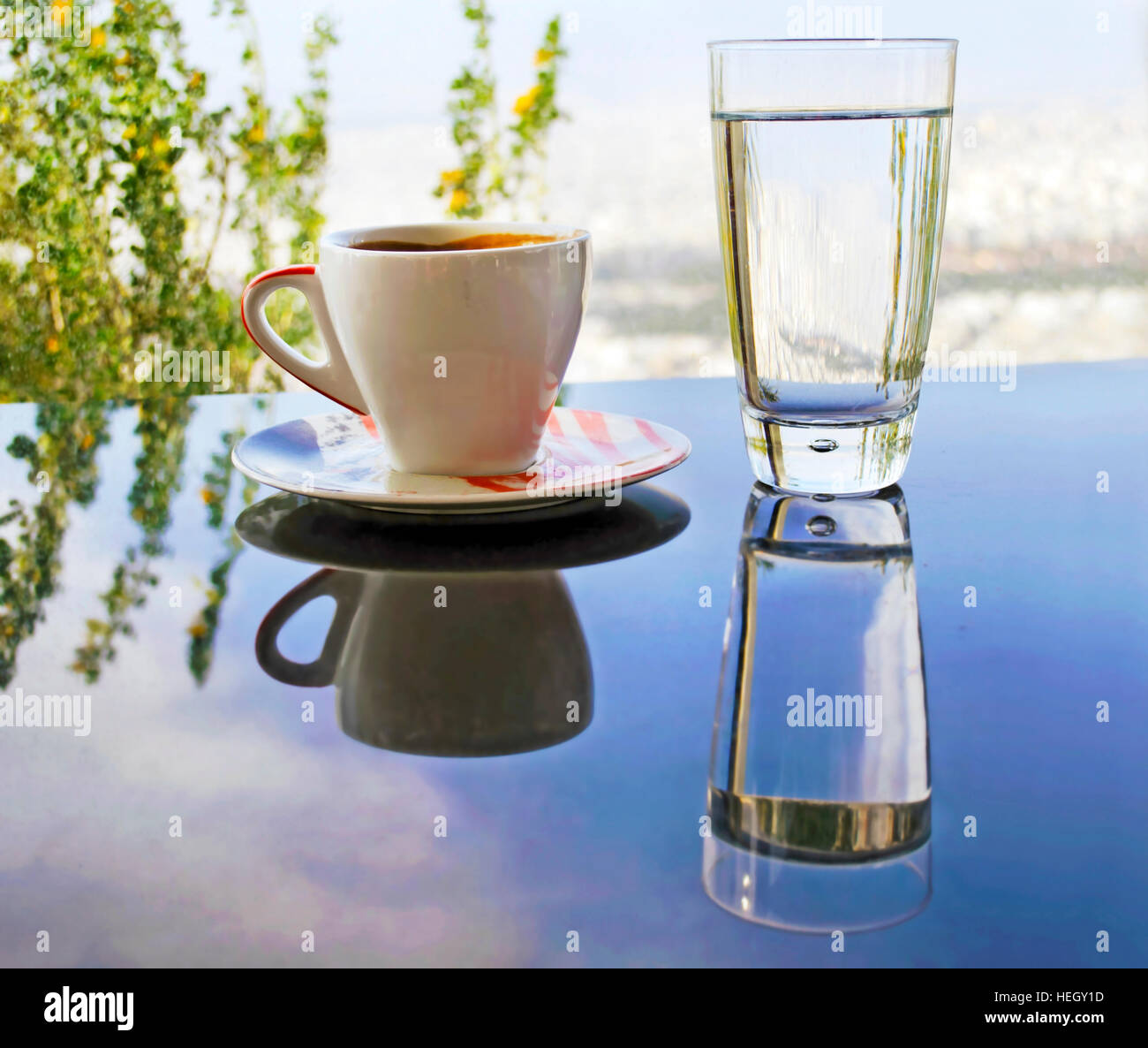Gafas reflexiones sobre la mesa - taza de cappuccino - vaso de agua  Fotografía de stock - Alamy