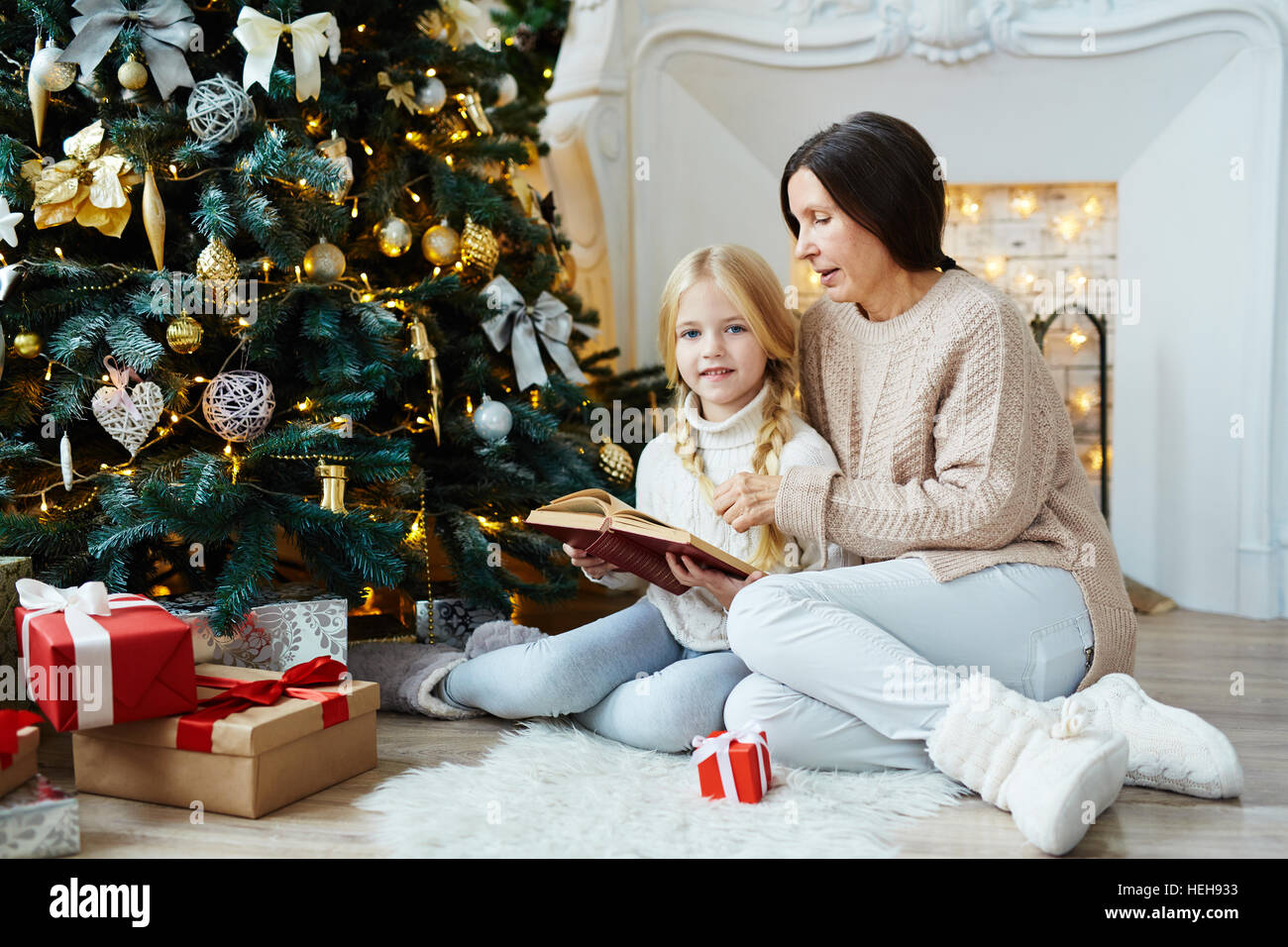 La abuela y la niña leyendo cuentos de Navidad decorado firtree Fotografía  de stock - Alamy