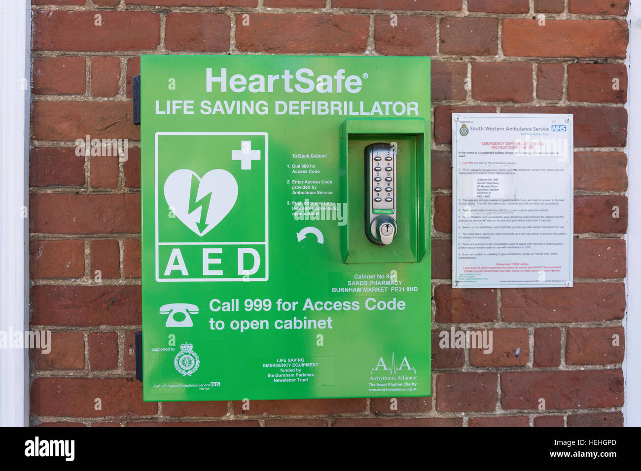 HeartSafe Defribrillator Salvan Vidas en pared exterior, el verde, el Mercado, el mercado de Burnham, Norfolk, Inglaterra, Reino Unido Foto de stock