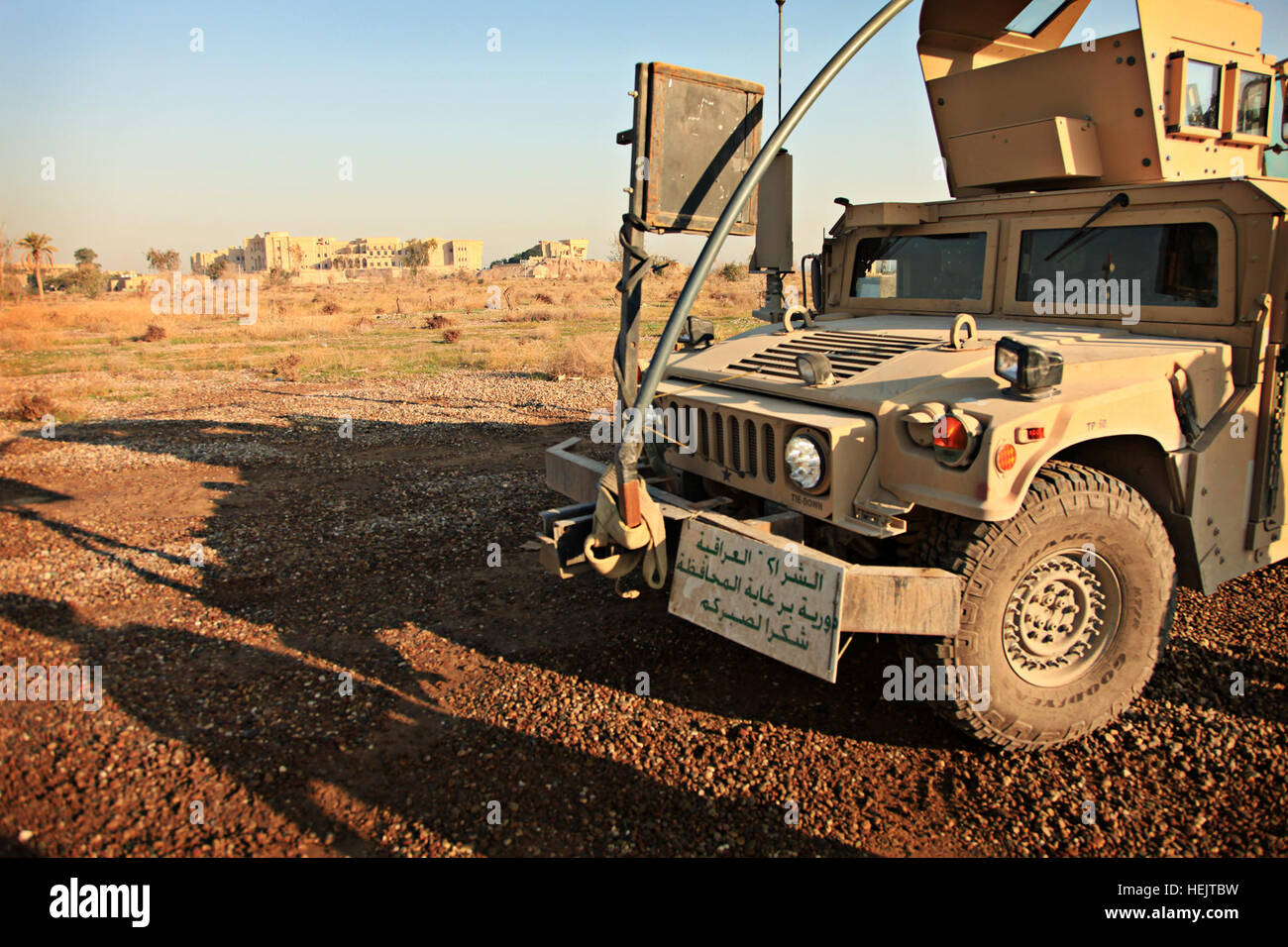 Un ejército de los EE.UU. de Alta Movilidad vehículo de ruedas multiuso está aparcado en las inmediaciones, mientras que soldados de EE.UU. asignados a Alpha BATERÍA, 2º Batallón del 32º Regimiento de Artillería de Campo, cuarta brigada equipo de combate, la 1ª División de Infantería, vaya al enlace con funcionarios locales en la estación de policía iraquí sobre la base de operaciones avanzada peligro cerca de Tikrit, Iraq, el 2 de diciembre de 2009. Las tropas de los EE.UU. operador básico enseñar clase mecánico en Tikrit 228717 Foto de stock