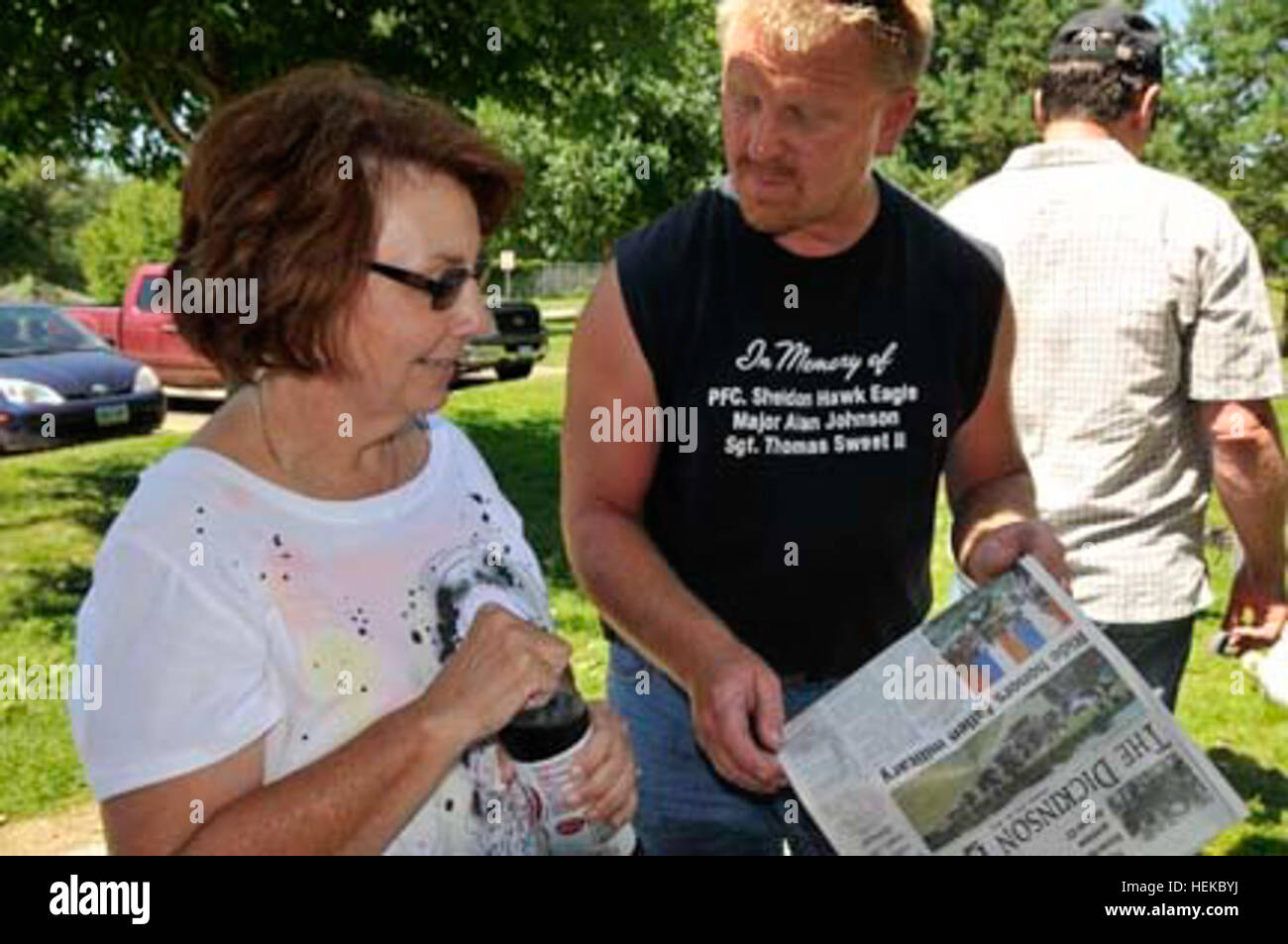 David Pagel, Fargo, Dakota del Norte, muestra Rhonda Holmes en Peoria, Arizona, un artículo de portada en el Dickinson Pulse sobre la quinta reunión anual de Dakota del Norte. Guardia patriota héroes caídos Memorial y Honor ejecutar, durante una reunión de la Guardia Nacional de Dakota del Norte la compañía C del 141º batallón de ingenieros de combate el 24 de julio, en Bismarck, Dakota del Norte. La unidad movilizados para la Operación Libertad Iraquí II desde diciembre de 2003 hasta febrero de 2005. Holmes, quien viajó 1.500 millas para asistir al evento, perdió a su hijo, Spc. James J. Holmes, 8 de mayo de 2004, a partir de las heridas infligidas por un dispositivo explosivo improvisado. Spc. Holmes, un nativ Arizona Foto de stock