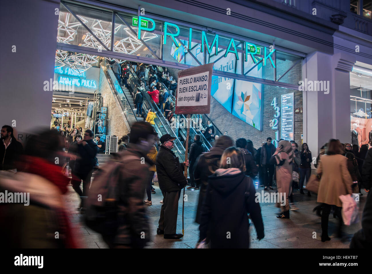 Madrid, España 23 de diciembre.Un montón de compradores de Navidad en el  centro de Madrid, España. En la imagen de un hombre delante de Primark  tienda con una pancarta \