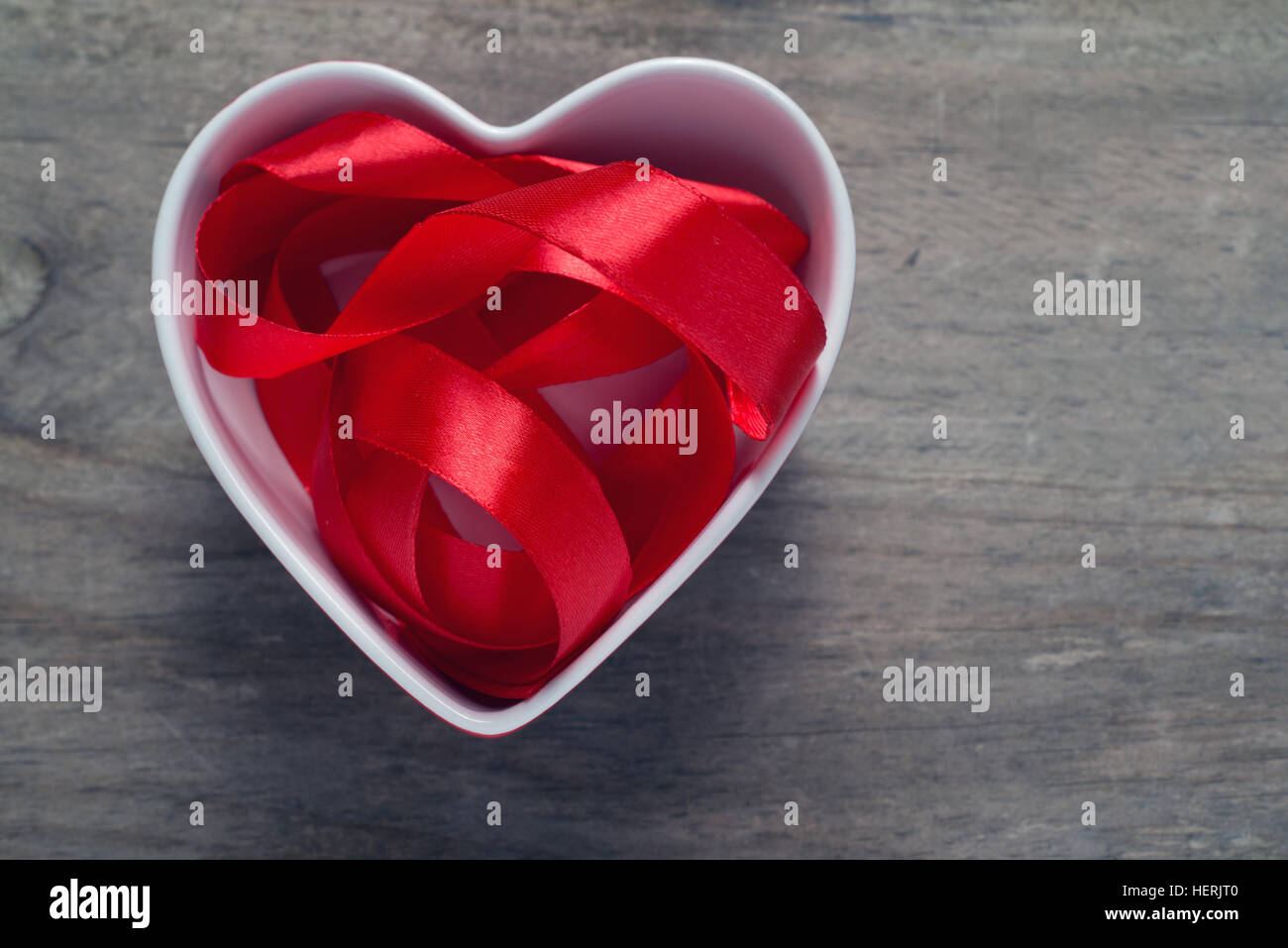 Cinta roja en un recipiente en forma de corazón; espacio para copiar Foto de stock