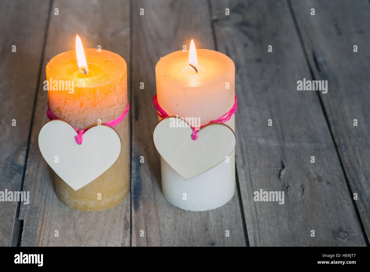 Dos corazones atados a dos velas encendidas. Espacio de copia Foto de stock