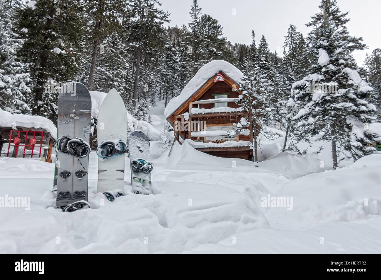 Snowboard en casa chalets en bosque de invierno con nieve en las montañas  Fotografía de stock - Alamy
