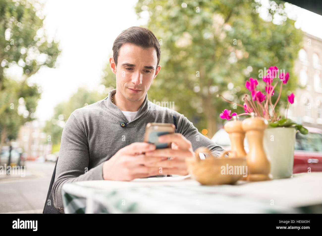 Hombre en cafeterías mirando el smartphone Foto de stock