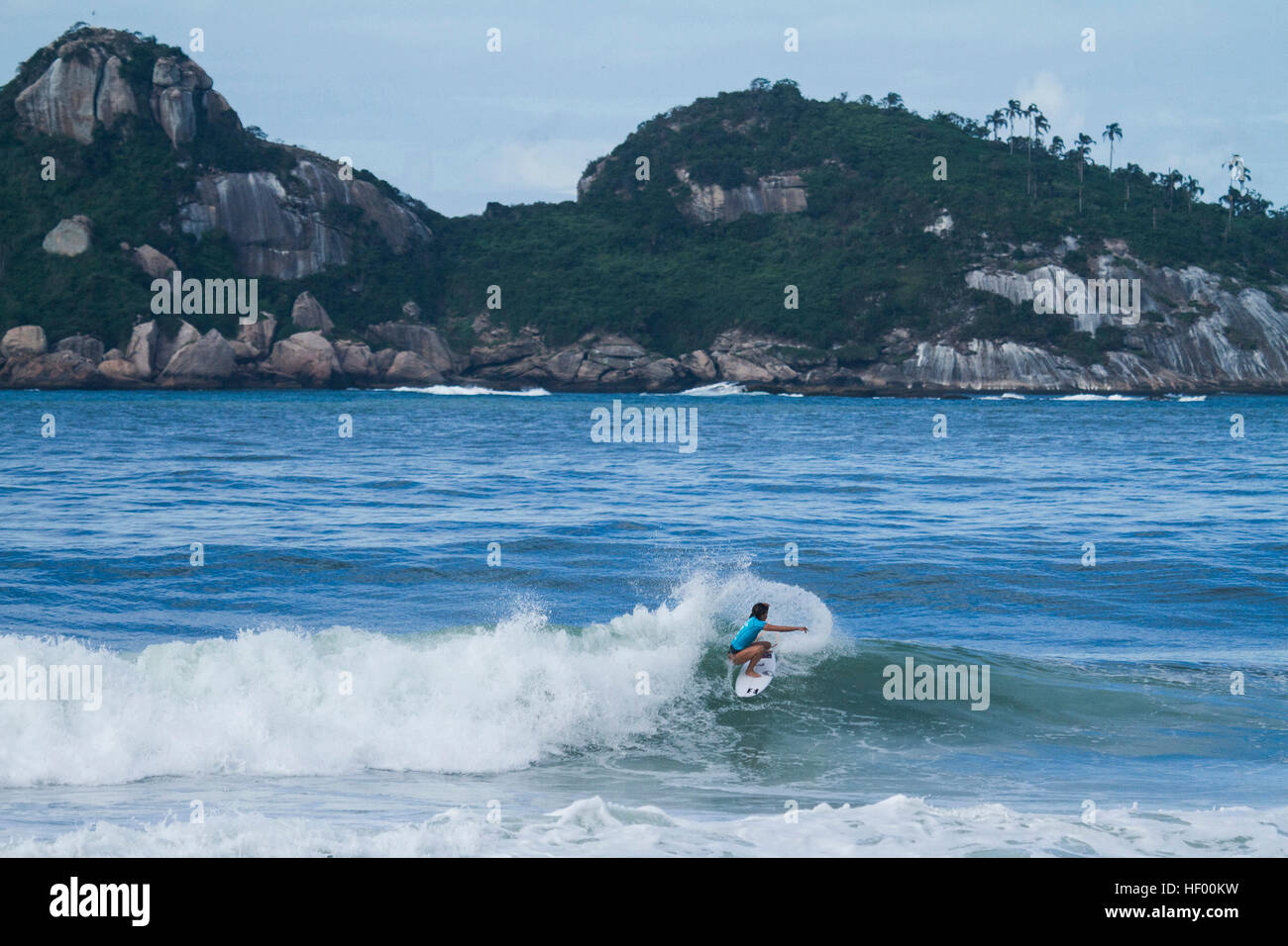 Surfista profesional femenino cabalgando una ola durante la competición Foto de stock