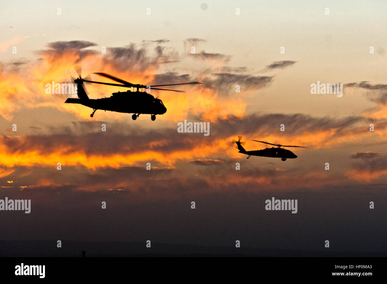 Dos helicópteros UH-60 Black Hawk sitúese sobre los cielos de Spin Boldak, en la provincia sureña de Kandahar, Afganistán, antes de volar. Un básico de transporte en Afganistán, helicópteros como éstas no sólo se utilizan para el transporte de tropas y de difícil acceso las bases de funcionamiento de avance, pero también como ambulancias aéreas. Flickr - DVIDSHUB - escucho los picadores hoverin' ... Foto de stock