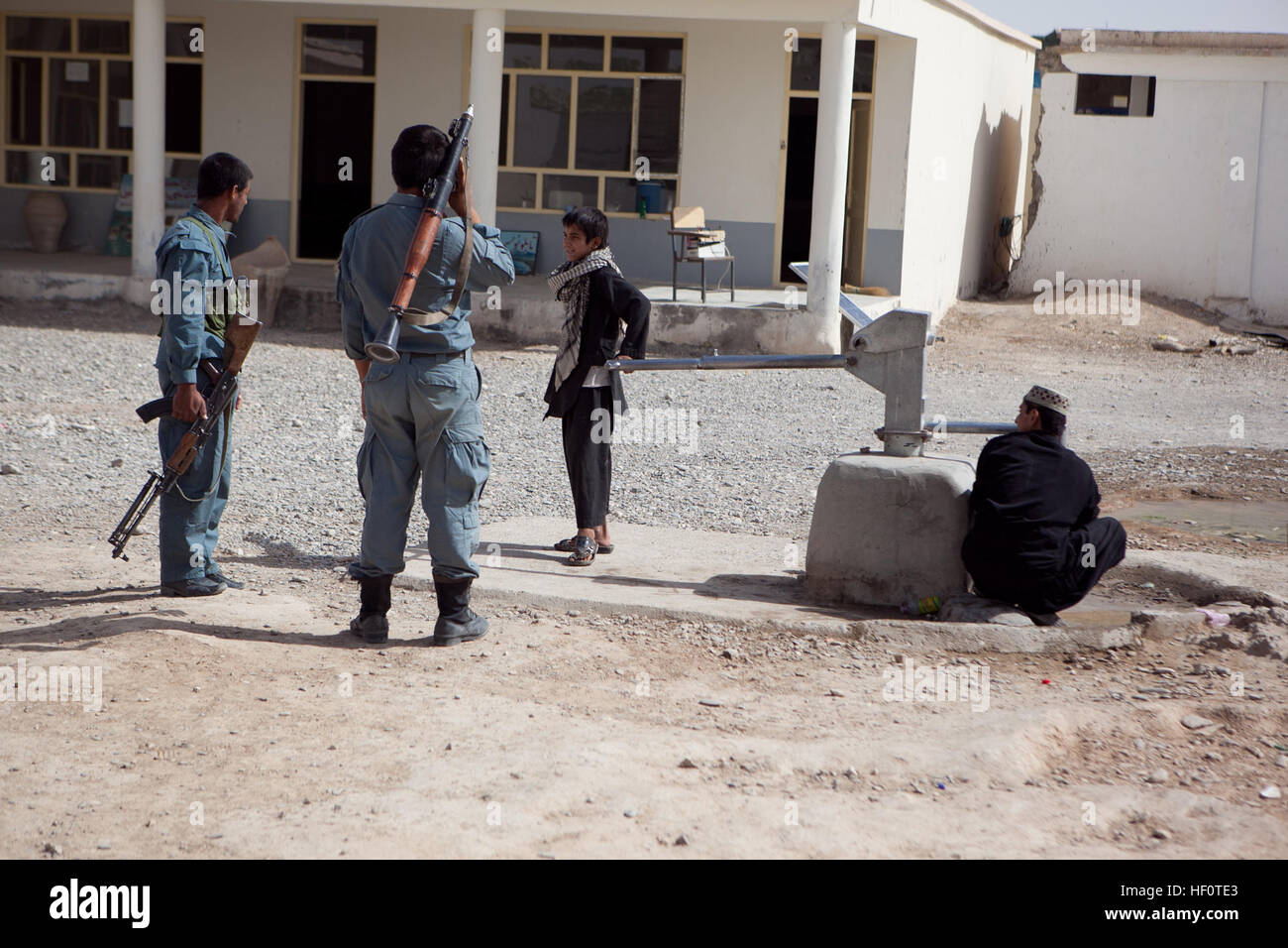 Dos policías uniformados afganos hable con dos estudiantes de la Escuela  Secundaria del muchacho Delaram, 17 de mayo de 2012. Alrededor de una  docena de policías del distrito centro trajo donó útiles