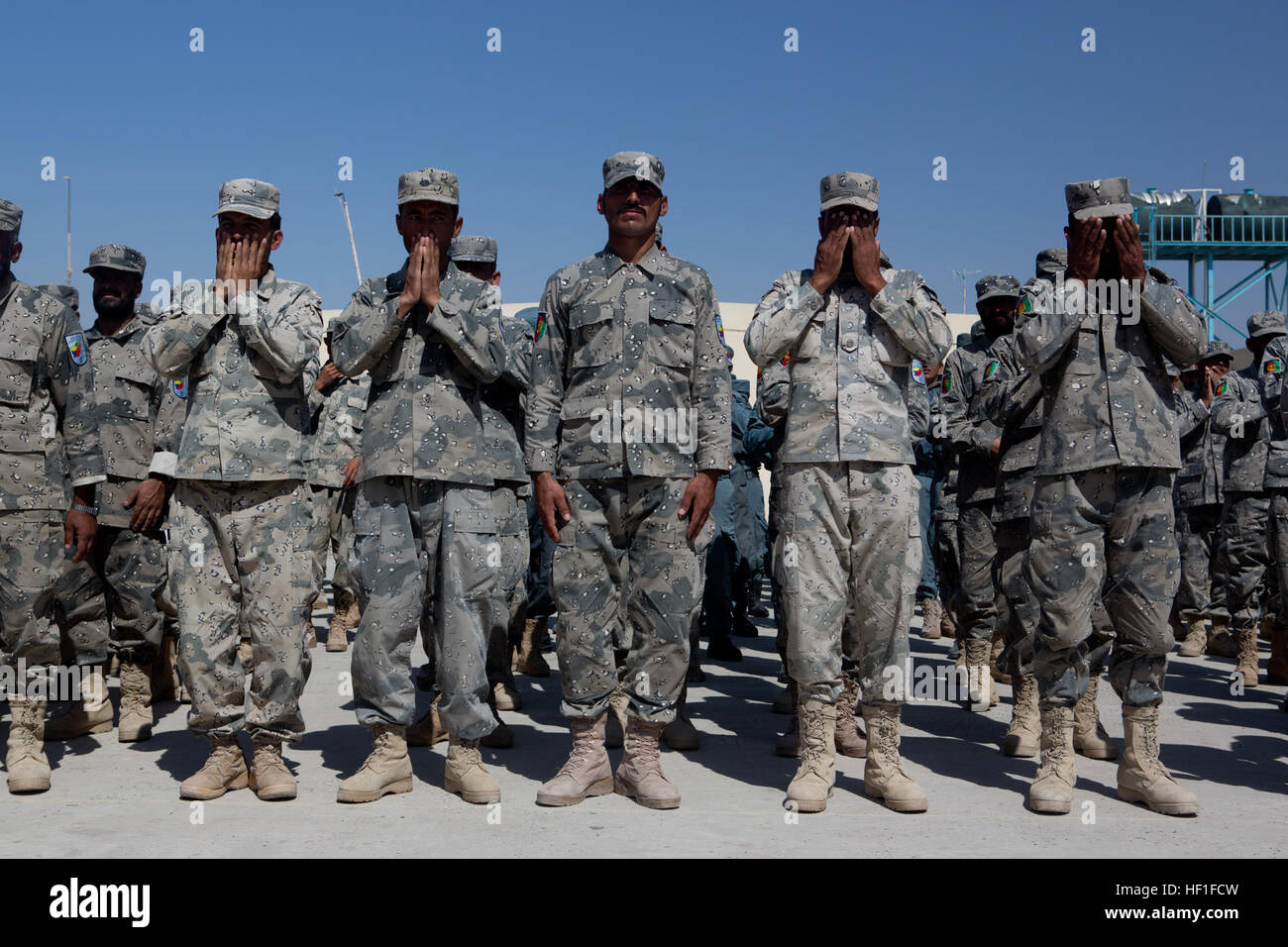 Los policías uniformados afganos orar durante una ceremonia en el Centro de Entrenamiento de Lashkar Gah (LTC) (LTC), la provincia de Helmand, Afganistán, el 10 de septiembre, 2013. Cuerpo de Marines de EE.UU Gral. Gen. Walter L. Miller Jr., comandante general del Comando Regional (Suroeste), y otros funcionarios visitaron el LTC para asistir a una ceremonia de corte de cinta para la inauguración de un nuevo complejo de formación. (Ee.Uu. Foto del Cuerpo de Infantería de Marina por el sargento. Tammy K. Hineline/liberado) Lashkar Gah de apertura del Centro de Formación 130910-M-RF397-091 Foto de stock