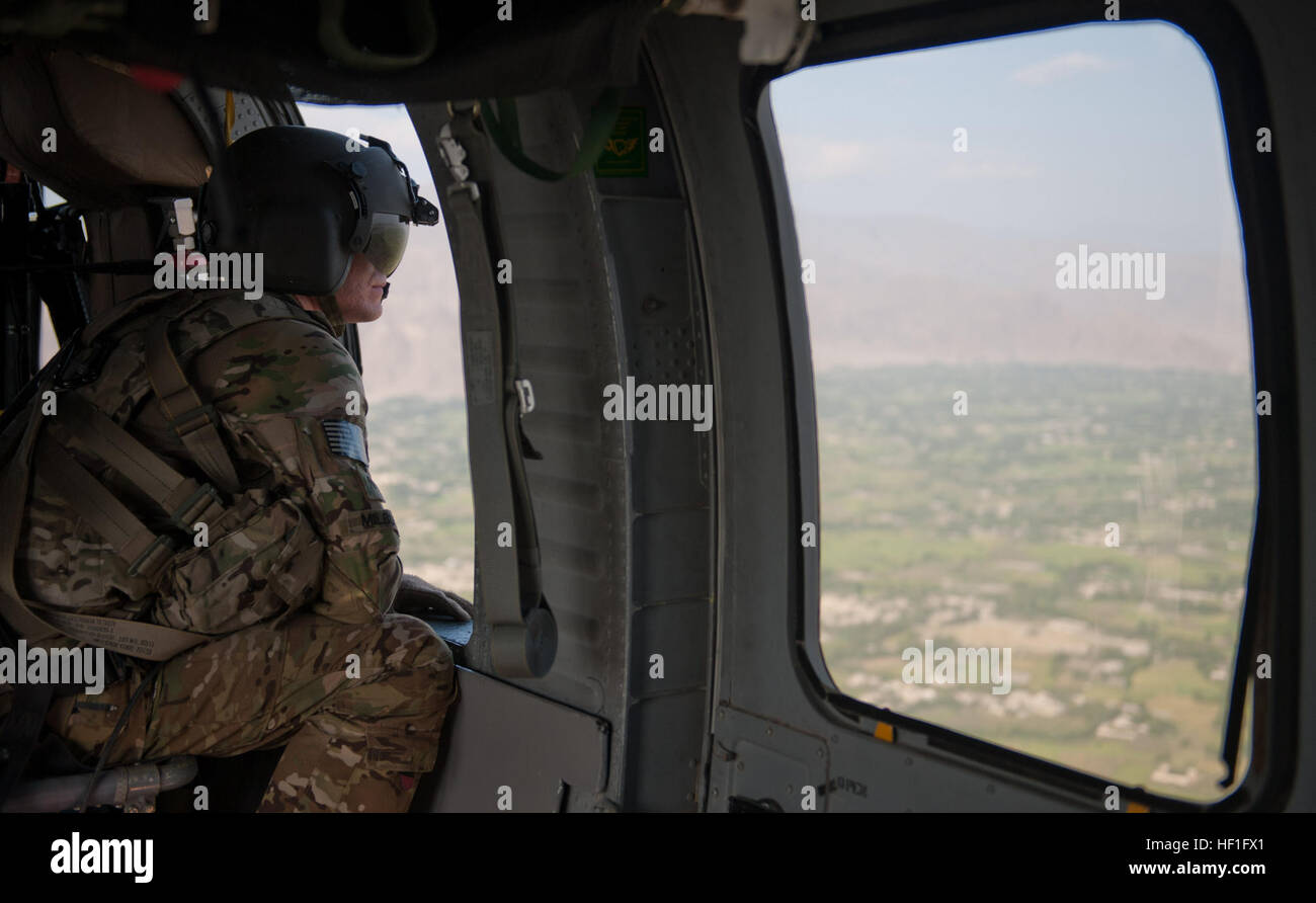 Spc del Ejército de Estados Unidos. Trevor Milbury, de sandwich, N.H., un jefe de la tripulación con el pelotón Medevac 'Dustoff', de la compañía C, 3er Batallón, 238ª Regimiento de Aviación, Task Force Dragon, explora el horizonte durante un ejercicio de entrenamiento de la grúa como su tripulación del helicóptero UH-60 Blackhawk vuela en Jalalabad, provincia de Nangarhar, Afganistán, el 16 de septiembre de 2013. Equipos de evacuación médica (MEDEVAC) proporcionar atención de emergencia a las fuerzas estadounidenses y de la Coalición, y transporte de pacientes por aire para instalaciones de atención médica. Utilizando un polipasto permite medevac tripulaciones para subir y bajar de suministros y personal en áreas remotas o traicionero donde aterrizar el avión i Foto de stock
