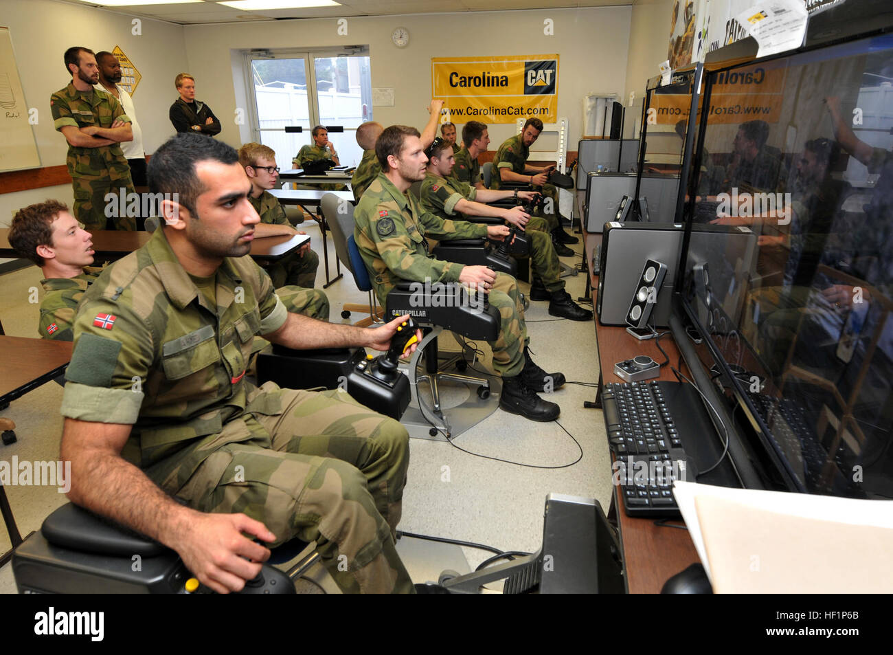 Ingeniero Militar noruego cadetes de la Academia Krigskolen, Noruega tiene una oportunidad para cross-tren con la Guardia Nacional Aérea de Carolina del Norte, 145° escuadrón de ingenieros civiles utilizando el programa de equipamiento pesado en simuladores de Stanly County Community College en Albemarle, N.C., el pasado 22 de octubre, 2013. Durante este ejercicio de dos semanas se celebró en el 145 en el sitio de Capacitación Regional CES New London, N.C., aviadores trabajó en colaboración con Noruega cadetes del ejército y la fuerza aérea en apoyo de la operación Guante impecable. La Guardia Nacional Aérea (foto por el Sargento Primero. Patricia F. Moran, 145ª Ala de Transporte Aéreo los asuntos públicos/Re Foto de stock