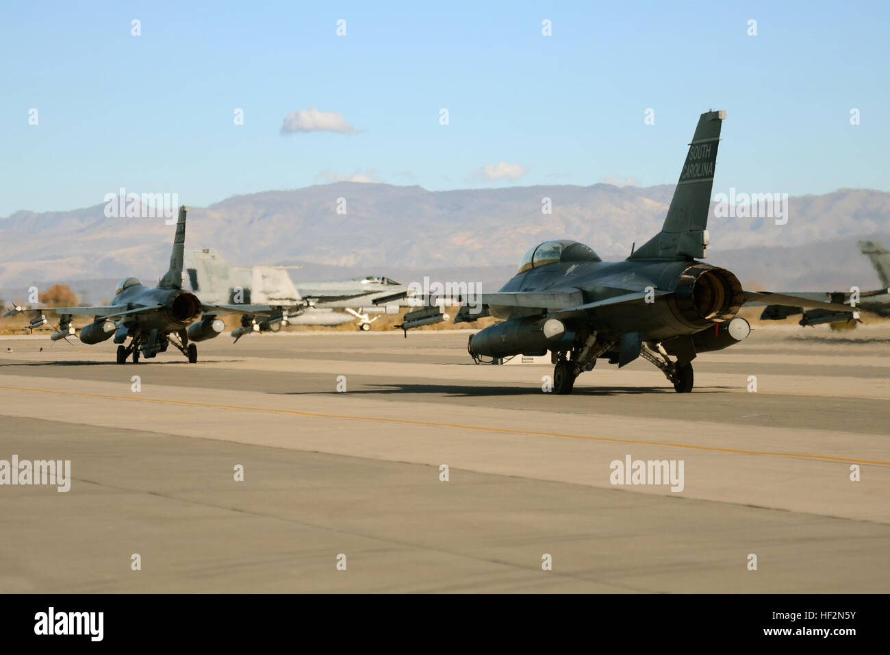 Los pilotos de combate de la Fuerza Aérea de los EE.UU. a partir de la 157ª Fighter Squadron en la base de la Guardia Nacional conjunto McEntire, S.C., espere en la línea de vuelo a taxi y lanzar F-16 Falcon de cazas de combate en una misión de entrenamiento desde la Estación Aeronaval Fallon, Nevada, 13 de noviembre de 2014. Swamp Fox aviadores de la 169ª Ala de caza y la Guardia Nacional Aérea de Carolina del Sur están desplegadas a NAS Fallon al apoyo Naval Air Wing uno con pre-despliegue de aviones de combate, integrando la formación F-16's de supresión de las defensas aéreas del enemigo (SEAD) capacidades con los pilotos de combate de la Marina de los EE.UU. (Ee.Uu. Guardia Nacional Aérea photo by Tech. El sargento Foto de stock