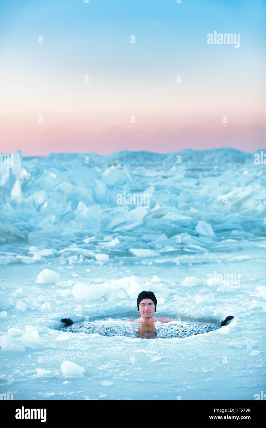 Piscina de Invierno. Hombre en un agujero de hielo. Foto de stock