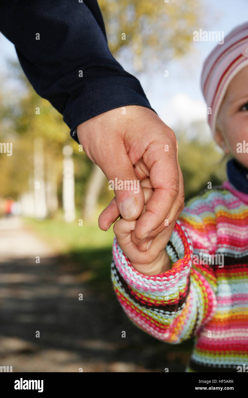 Padre y su hija de tres años la celebración de manos Foto de stock
