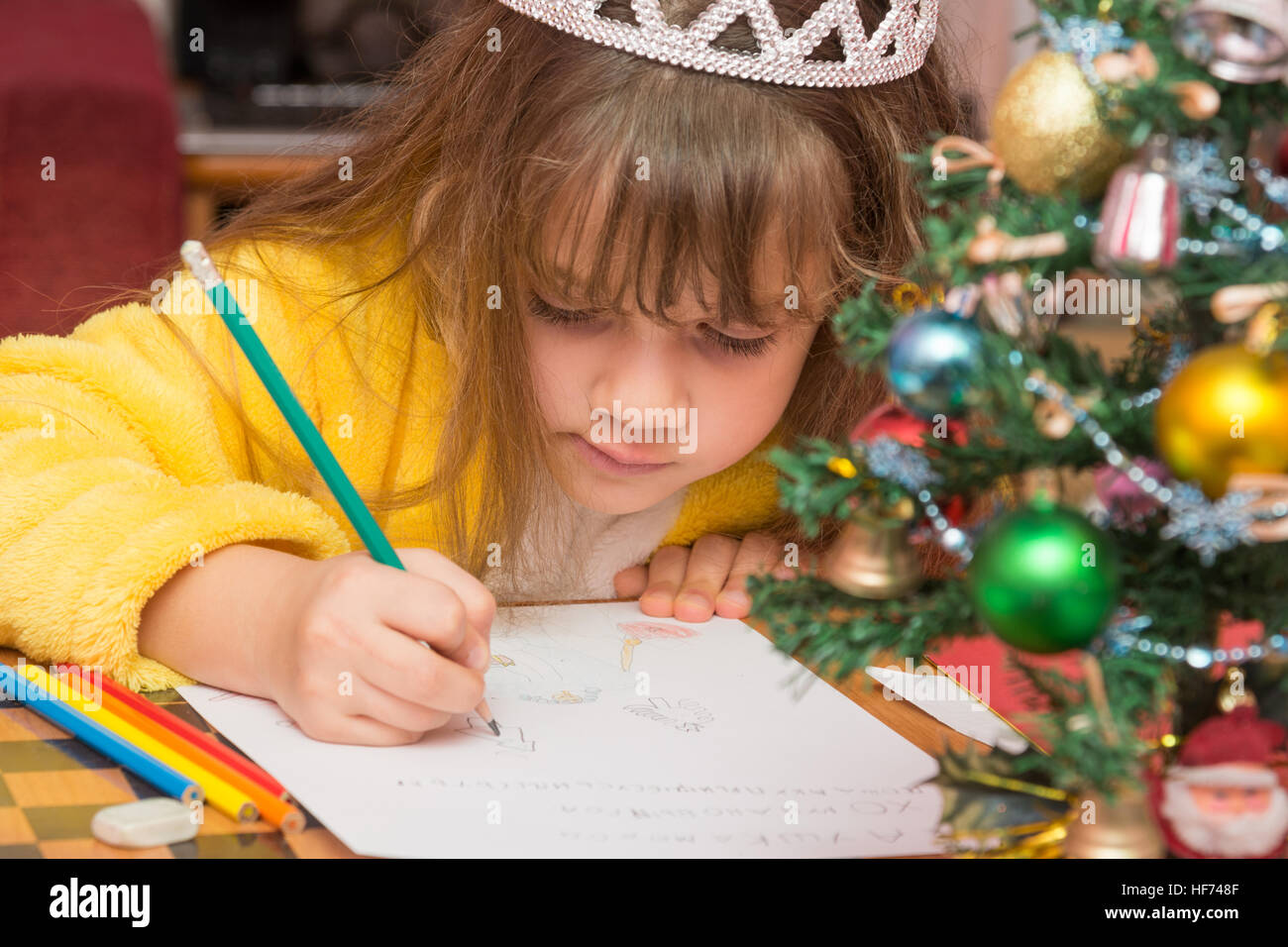 La niña dibuja en una carta a Santa Claus Foto de stock