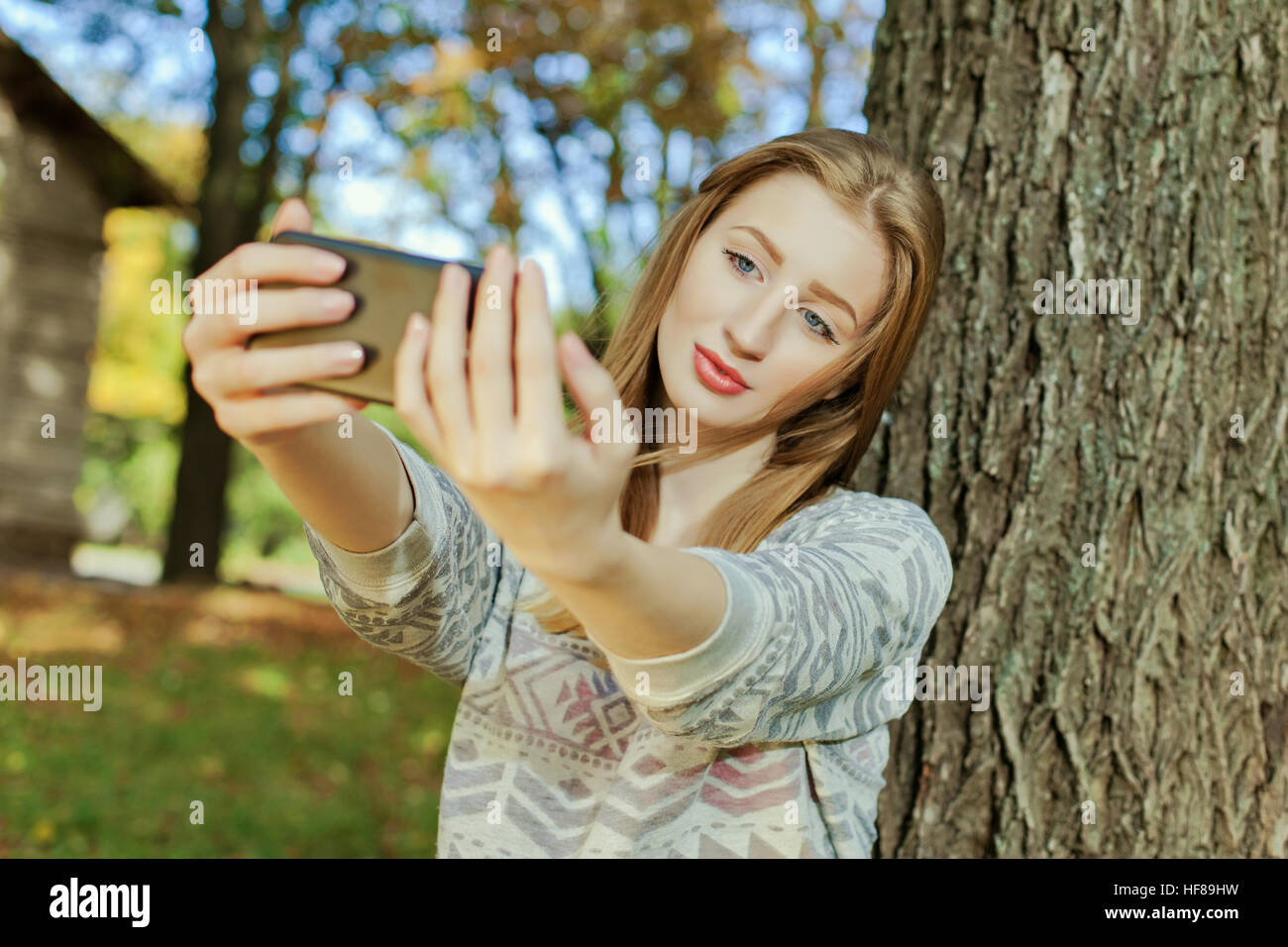 Hermosa chica con ojos azules hace selfie afuera Foto de stock