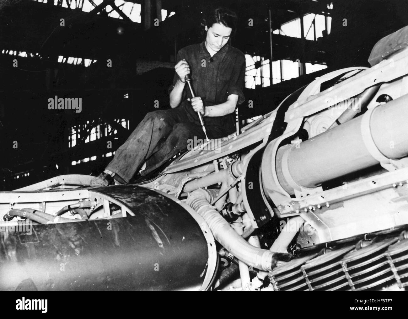 La imagen de la propaganda nazi muestra a una mujer montando un avión de combate Heinkel He 111 en la sala de la línea de montaje de Ernst Heinkel Plane Manufacturers. Publicado en mayo de 1942. Un reportero nazi ha escrito en el reverso en 01.05.1942, 'El hombre y sus obras. El montaje de la cubierta del motor del avión de combate Heinkel es trabajo de las mujeres. [Otras imágenes de esta serie de fotos están bajo el título, 'Der Mann und sein Werk' (El hombre y sus obras - refiriéndose a Ernst Heinkel, fabricante de aviones).] Fotoarchiv für Zeitgeschichte - SIN SERVICIO INALÁMBRICO - | uso en todo el mundo Foto de stock