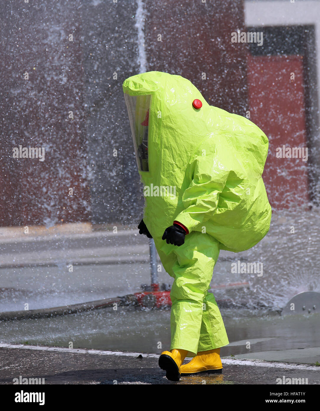 El bombero con traje amarillo grande contra el riesgo biológico durante un ejercicio de entrenamiento Foto de stock