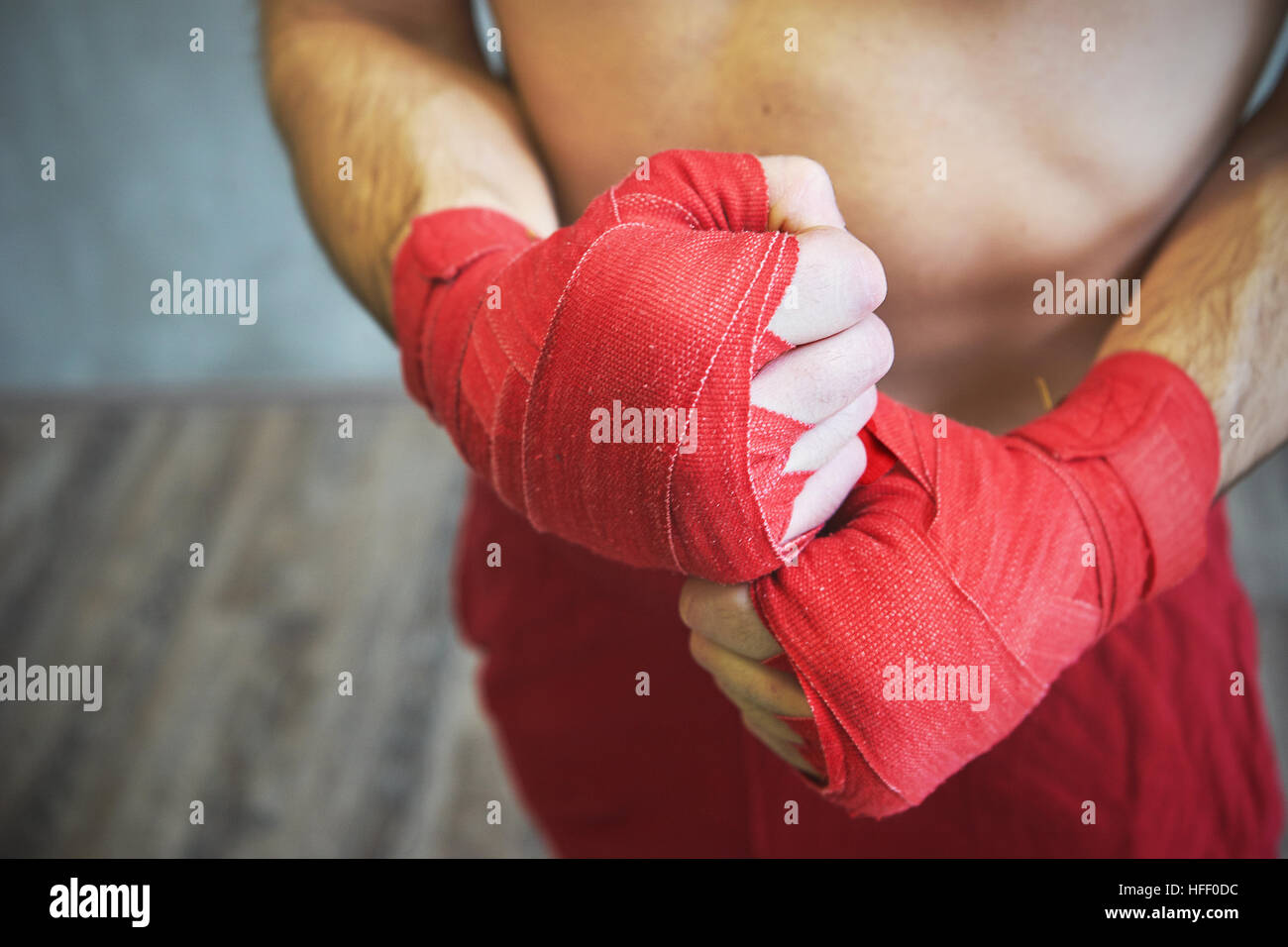 Foto de manos envuelto con cinta de boxeo rojo de joven boxeador