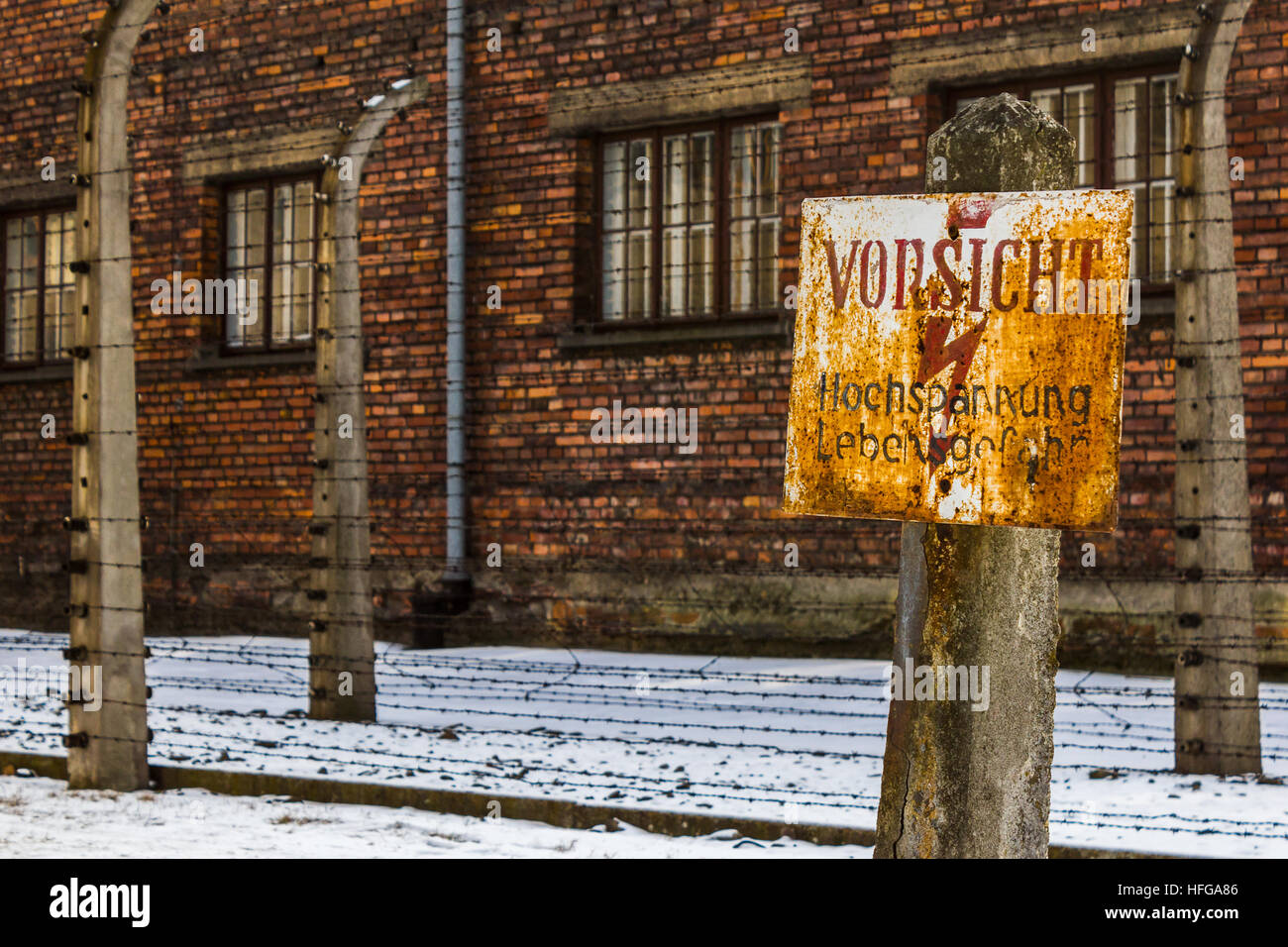 Cartel "vorsicht hochspannung lebensgefahr' fue visto delante de algunas de las cercas electrificadas que estaban en Auschwitz. Foto de stock
