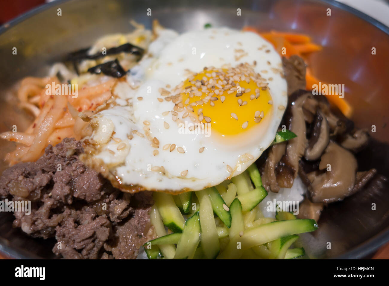 Bibimbap coreano arroz mixto salteado de verduras carne en rodajas de huevo frito Foto de stock