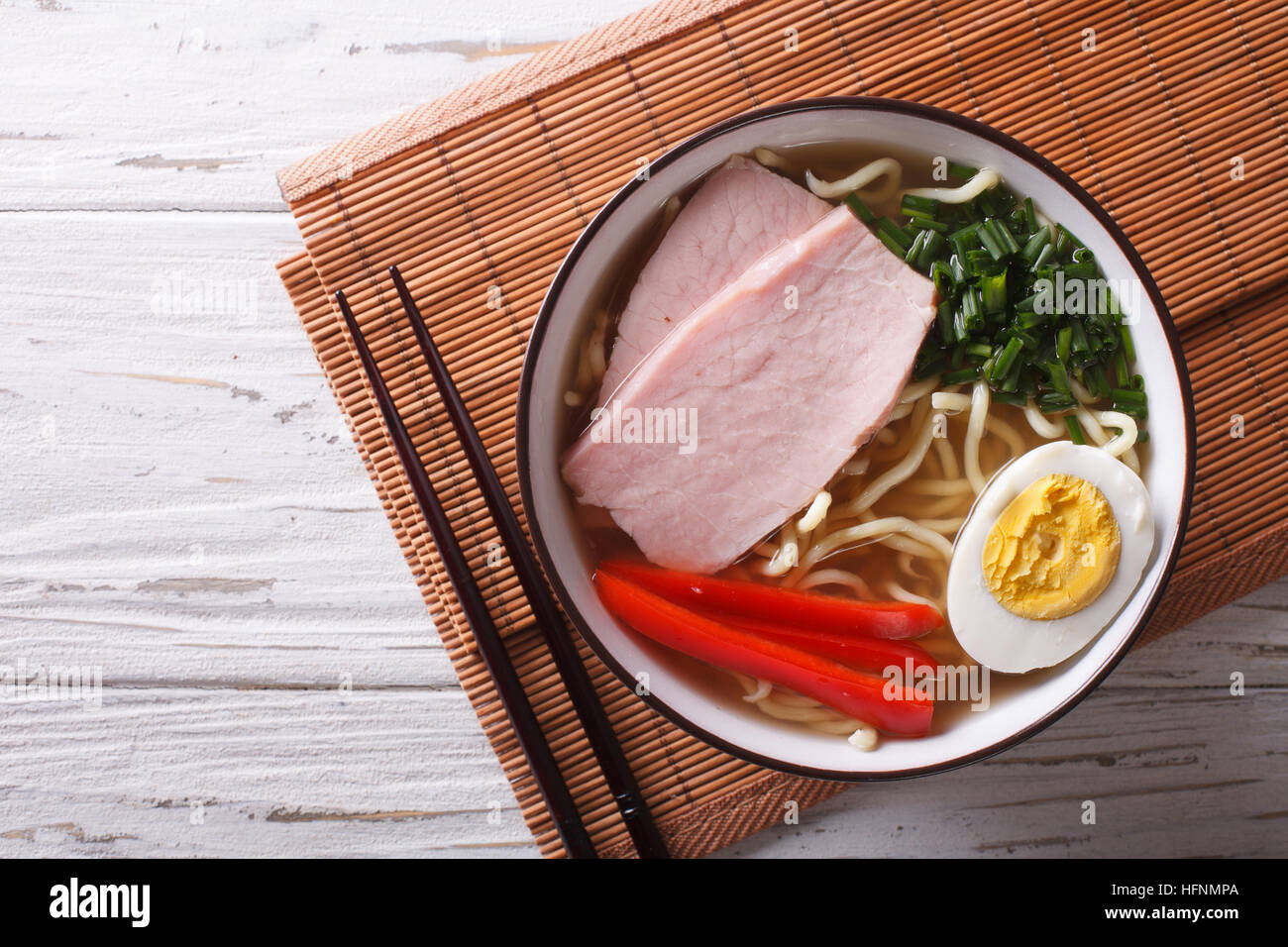 La comida asiática: caldo de fideos ramen con carne de cerdo, las verduras y el huevo en un tazón de cerca. Vista superior horizontal Foto de stock