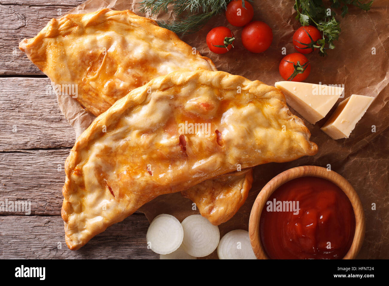 Calzone pizza italiana en un papel de primer plano y los ingredientes