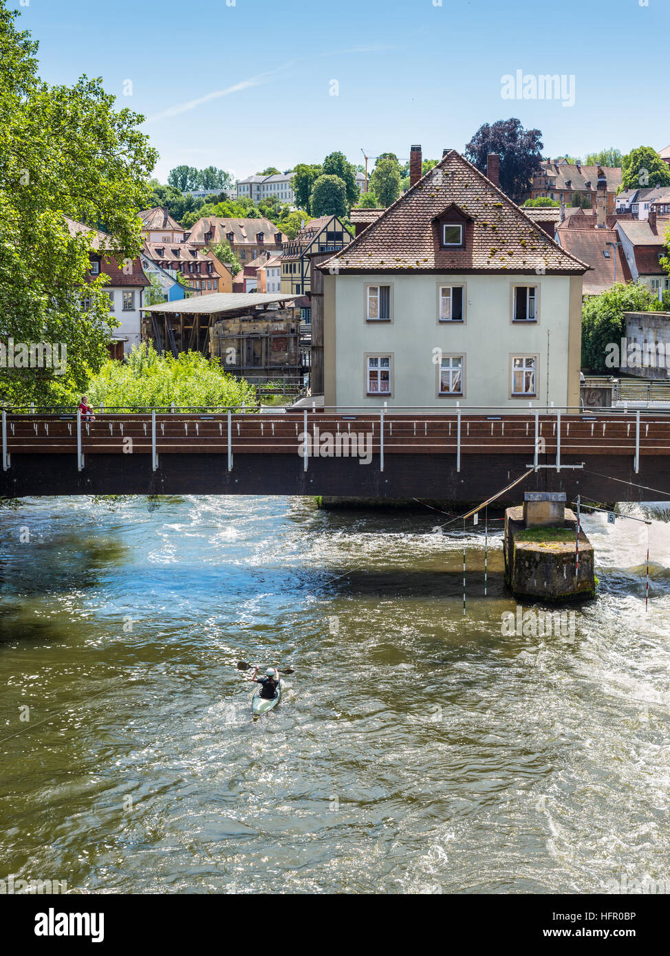 Kayakista sobre el río Regnitz contra el fondo del puente, y la arquitectura de la ciudad vieja de Bamberg Foto de stock