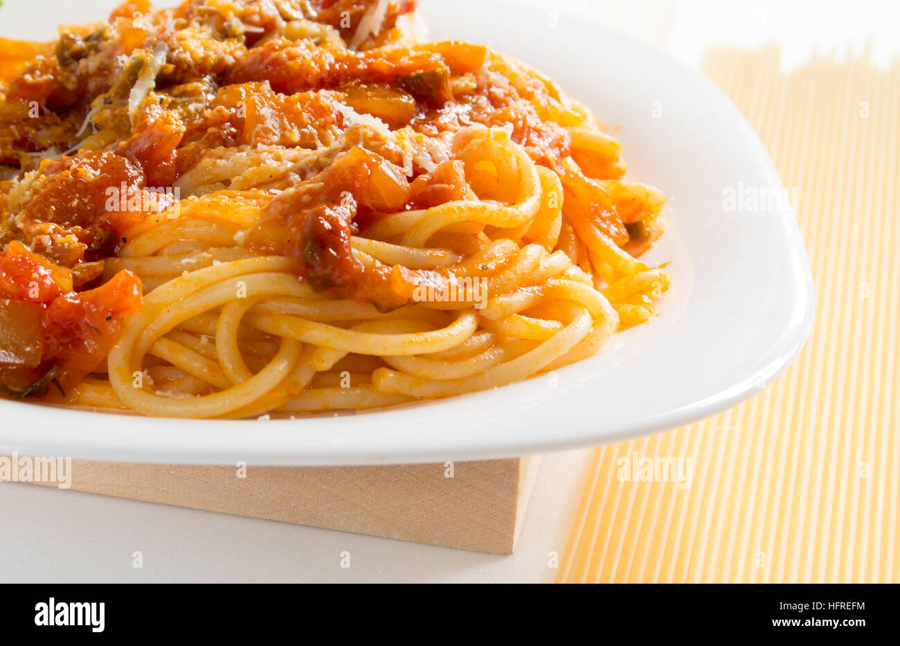 Cocinó espaguetis con boloñesa y queso parmesano en una placa blanca closeup Foto de stock