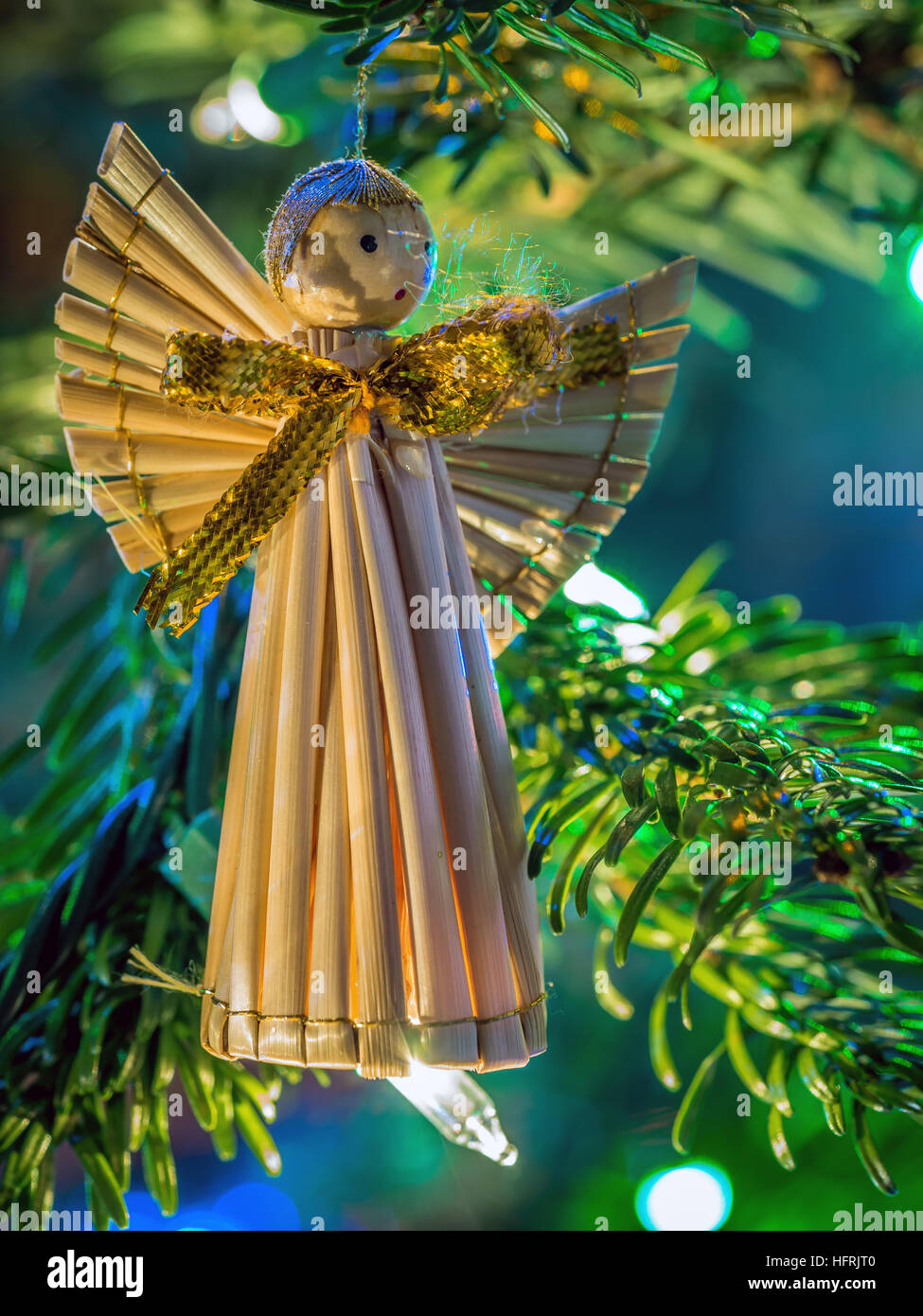 Ángel de Navidad de paja colgando en el árbol de navidad Foto de stock