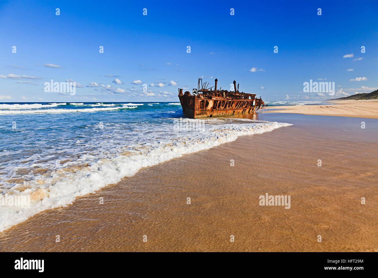 Historis SS Maheno naufragio en Isla Fraser playa oxidando abajo en un día soleado de verano. Foto de stock