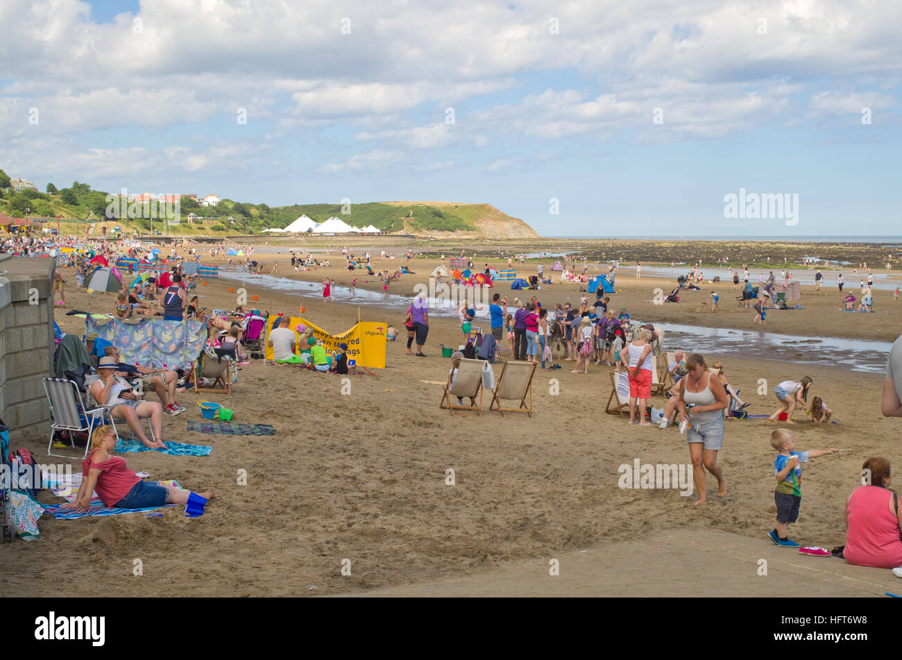 Los turistas veraneantes en la playa norte de la bahía de la costa de North Yorkshire Scarborough UK Foto de stock