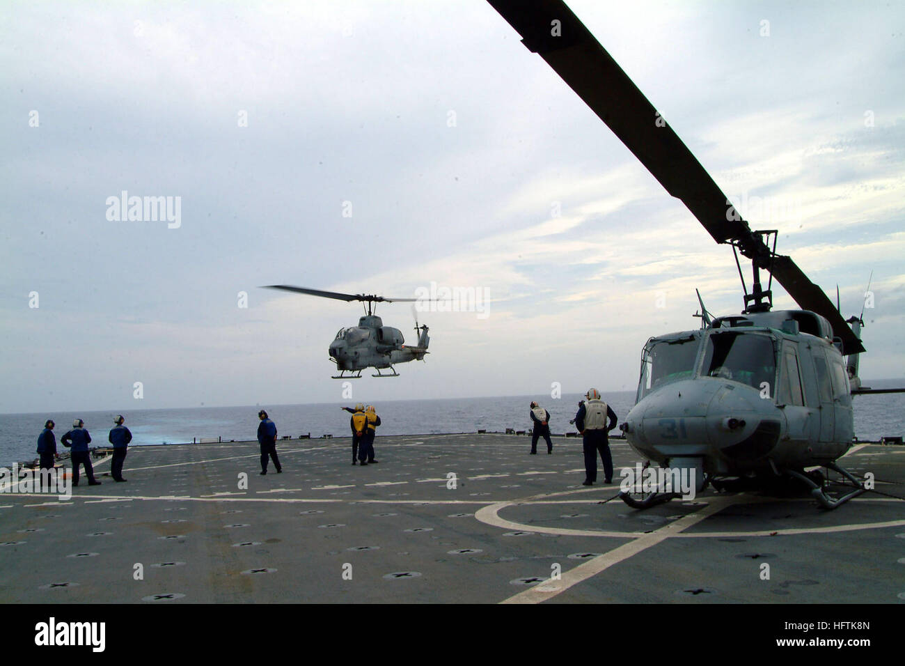 N 4772b 018 El Mar De China Oriental 8 De Julio De 05 D Un U S Marine Corps Huey Uh 1n Se Encadena Abajo En La Cubierta De Vuelo Como Un Ah 1w Super Cobra Llega