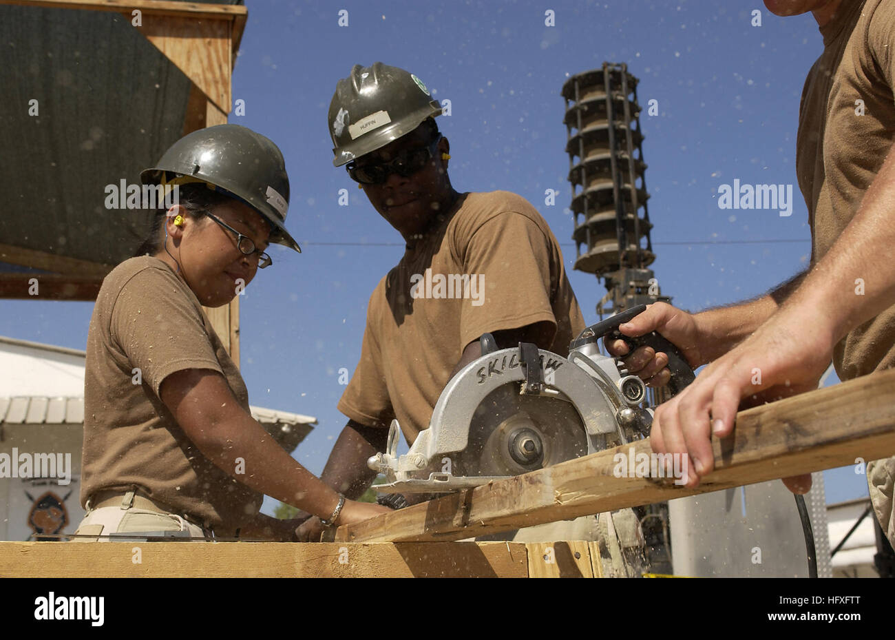 Aurora Constructionmen Bahr, Tyrone Huffin y Chad Smith cortar la leña que se utilizará para hacer pisos para nuevos edificios, móvil de Construcción Naval Batallón 3, Camp Lemonier, Djibouti, el 8 de noviembre, 2005. Los dos nuevos edificios se utilizará para combinar y casa la Joint Task Force-Horn de África para el futuro personal de operaciones, que actualmente están separados en diferentes tiendas. (Liberado) (U.S. Foto de la fuerza aérea por el Sargento. Stacy L. Pearsall) US Navy 051108-F-7234P-043 de la Marina de los EE.UU Aurora Constructionmen Bahr, Tyrone Huffin y Chad Smith, todos asignados al Batallón móvil de Construcción Naval tres (NMC Foto de stock