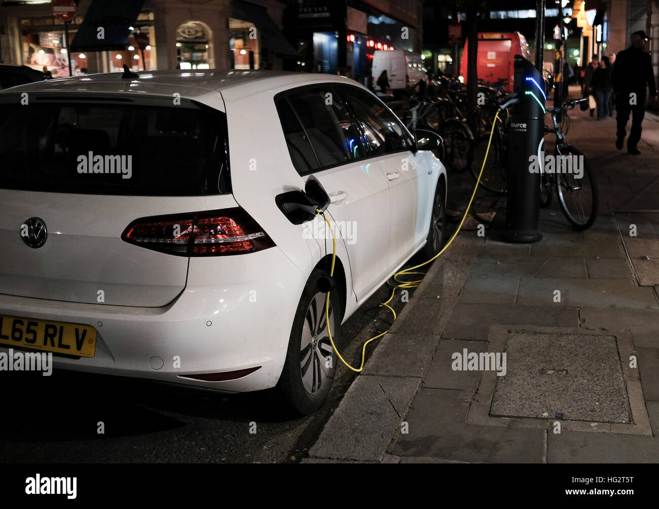 VW Golf eléctrico de carga en las calles de Londres de noche Foto de stock