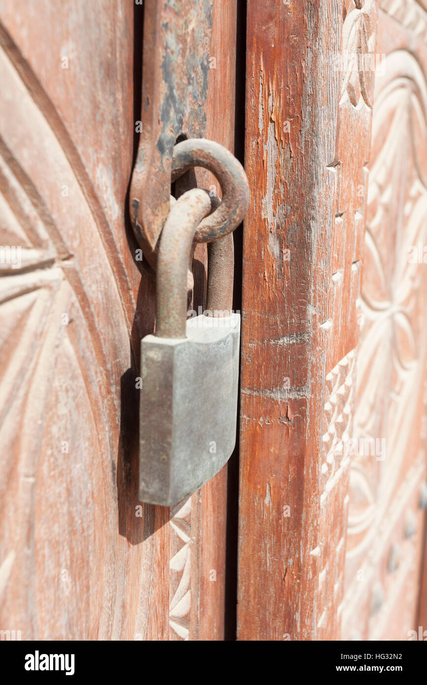 Oxidado viejo candado de una puerta de madera con tallas Foto de stock
