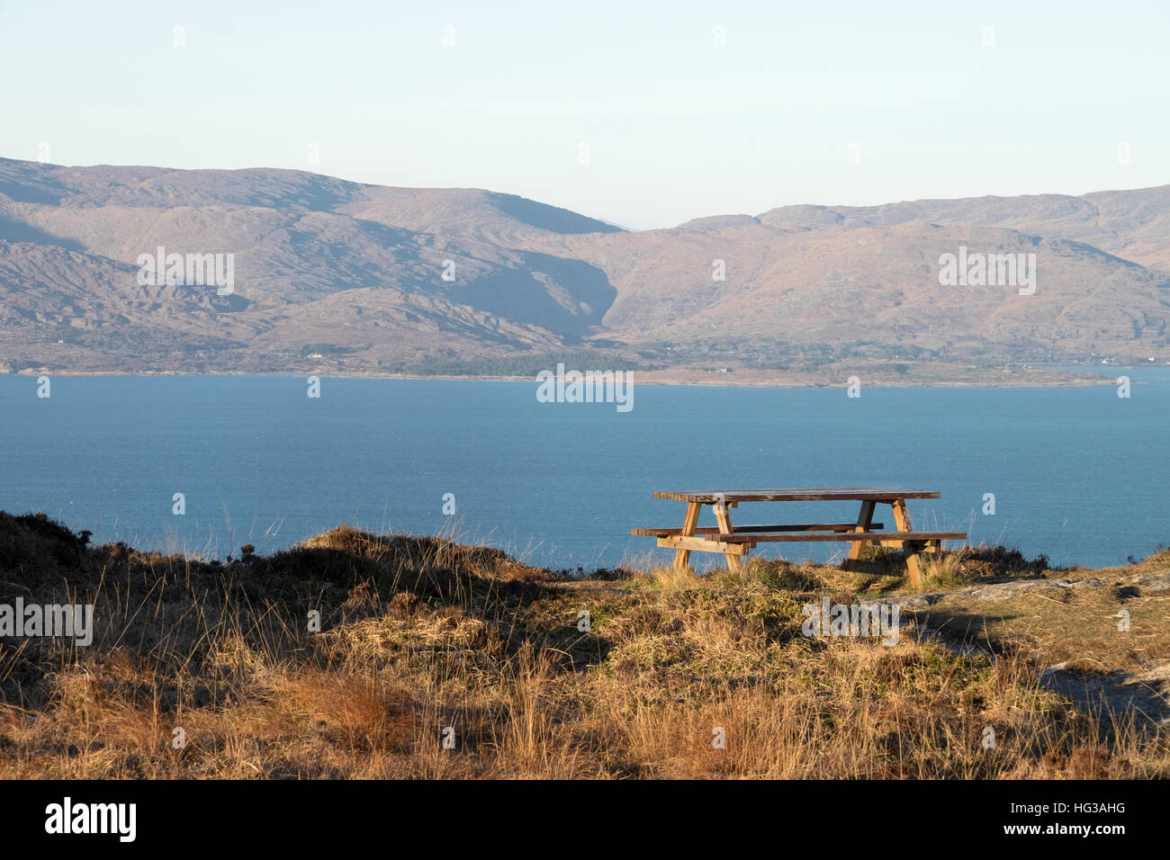 Una mesa de picnic en la península de cabeza de Oveja County Cork Ireland mirando hacia el norte cruzando la bahía de Bantry a las montañas de CAHA Foto de stock