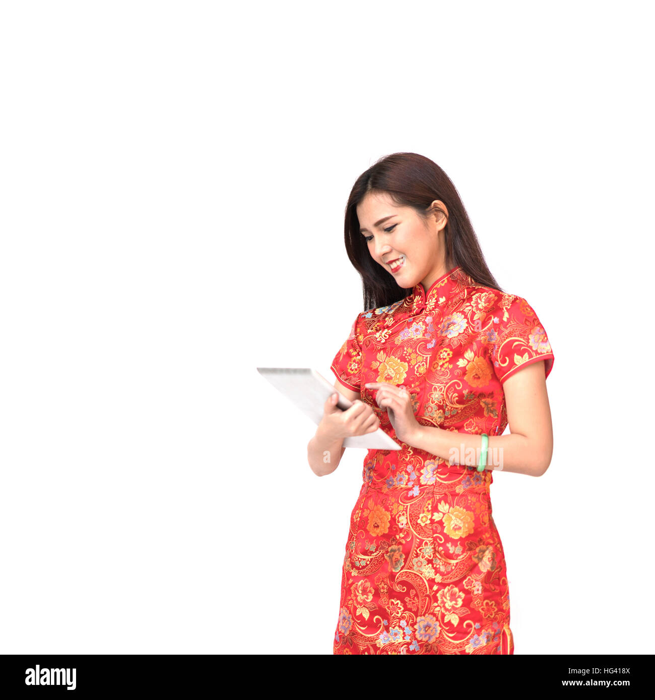 Hermosa muchacha asiática en chino Qipao vestido tradicional mediante tableta digital, el año nuevo chino y el concepto de tecnología moderna, aislado en blanco backgr Foto de stock