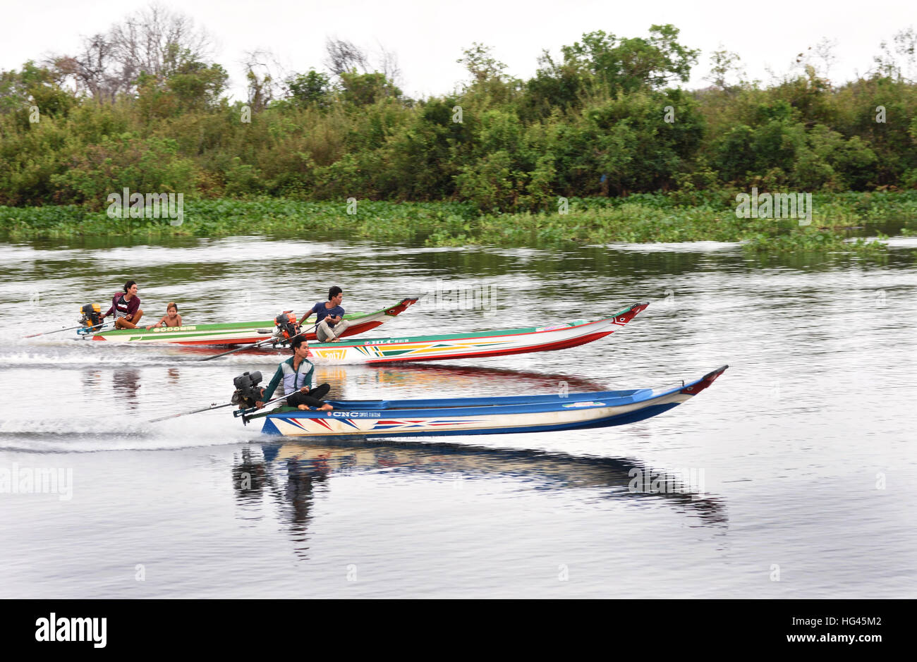 Los hombres jóvenes de carreras de barcos en el río Sangker Sangkhae - La provincia de Battambang, Camboya.el lago de agua dulce Tonlé Sap ( lago de pesca más ricos del mundo ) se drena en el río Mekong en Phnom Penh. La población camboyana local también se ha adaptado a la ecología única del lago flotante ( pescadores -pesquería ) aldeas y casas tiesos. Foto de stock