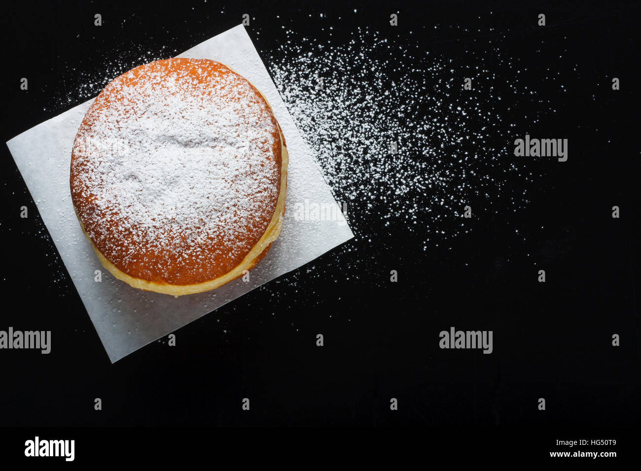 Donut y azúcar en polvo sobre fondo oscuro Foto de stock