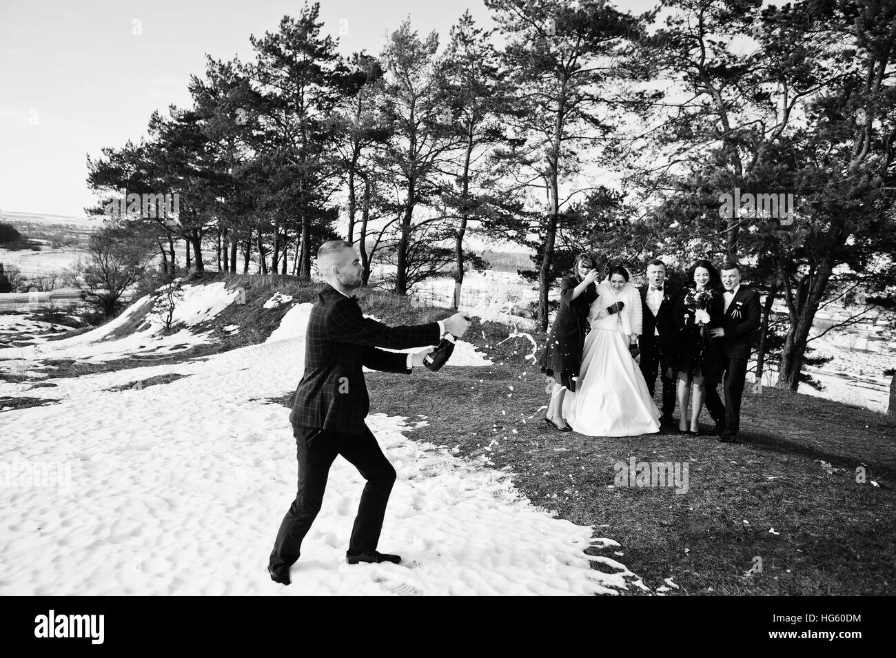 El mejor hombre con damas de honor y los recién casados beber champán en hielo en invierno día de boda. Fotografía en blanco y negro Foto de stock