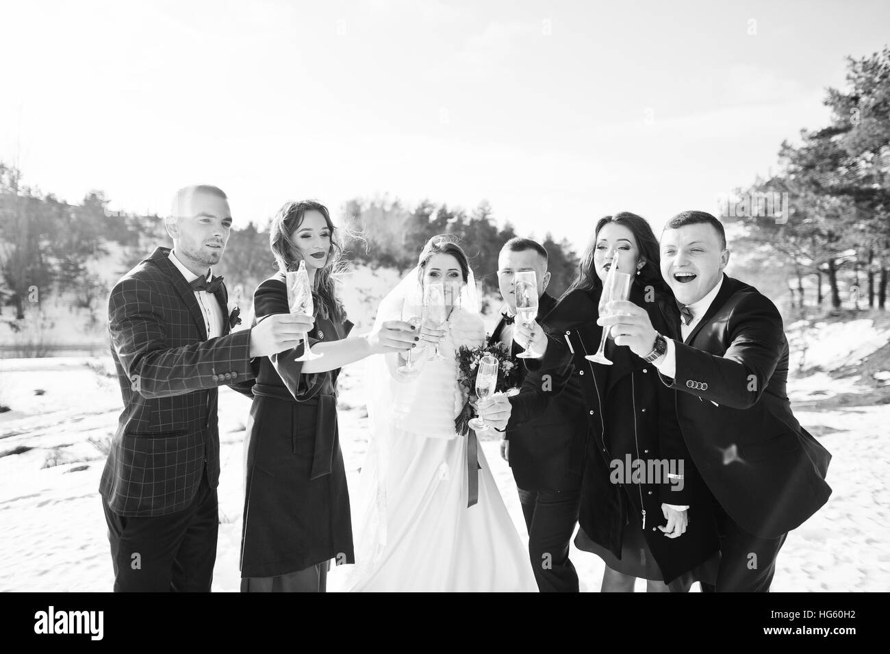 El mejor hombre con damas de honor y los recién casados beber champán en hielo en invierno día de boda. Foto de stock