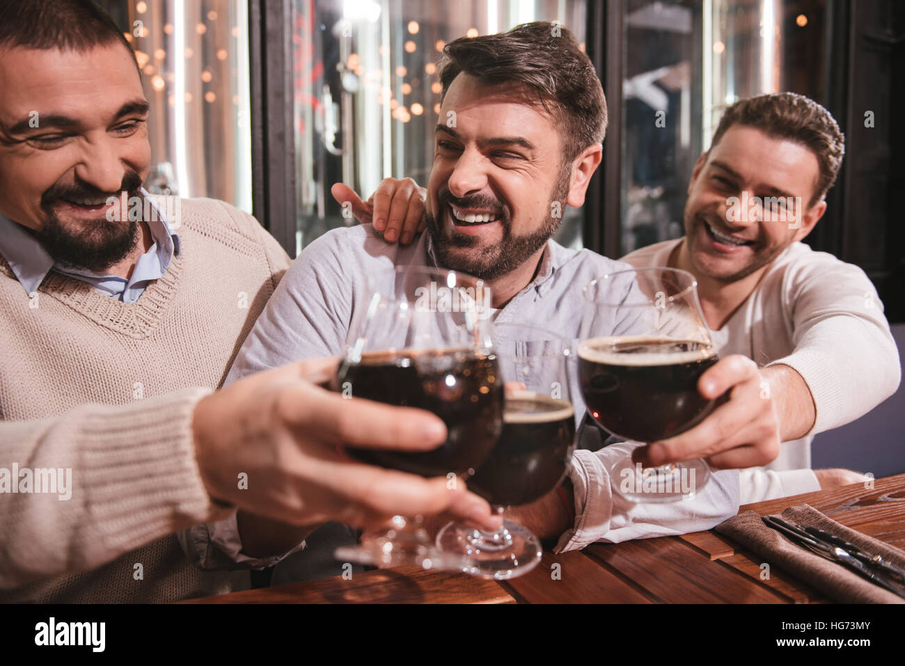 Encantado gozoso hombres beber alcohol Foto de stock