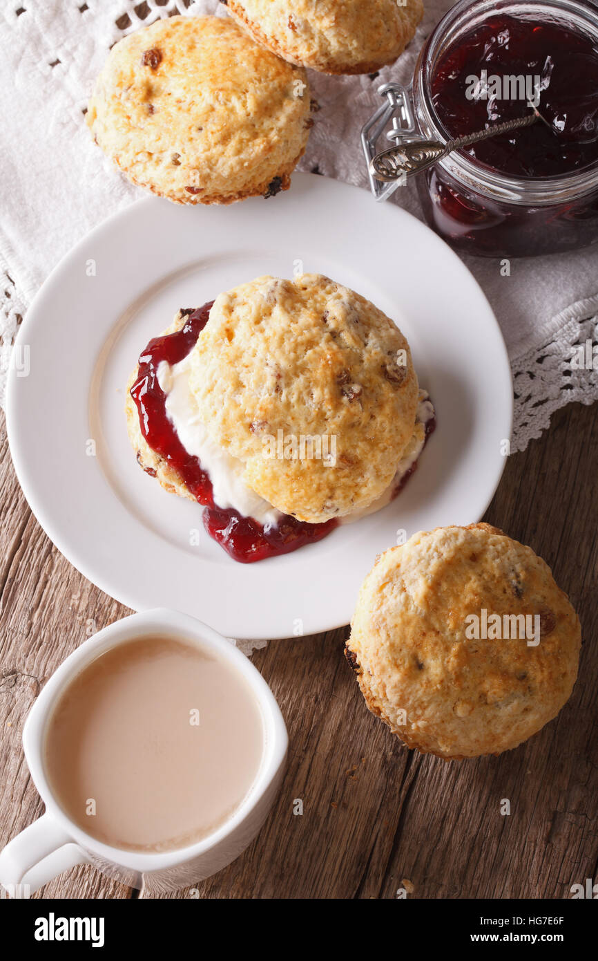 Deliciosos scones ingleses con mermelada y té con leche de cerca en la  tabla vertical Fotografía de stock - Alamy